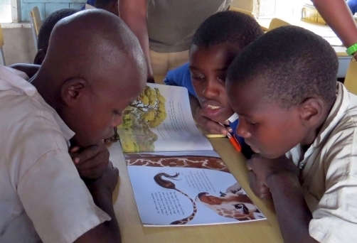 Children reading giraffe-themed education materials_Wild Nature Institute