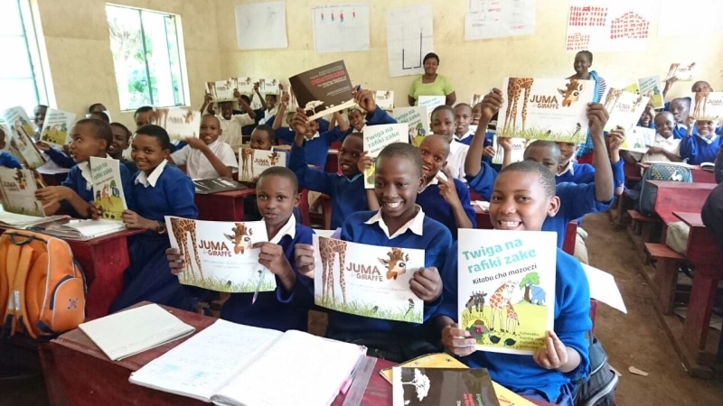 Tanznian schoolchildren receive giraffe books. Wild Nature Institute.